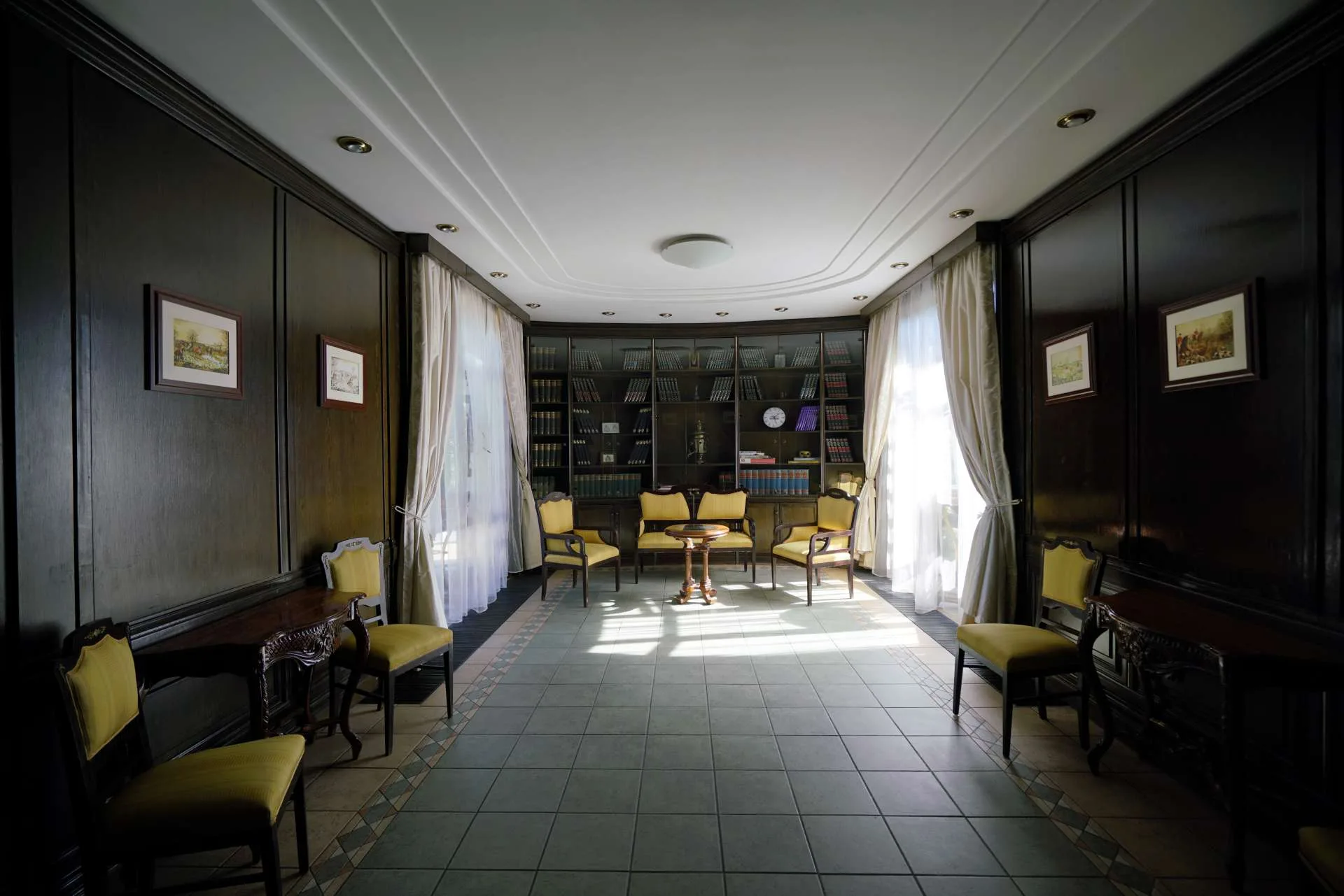Cabinetul de vinuri cu bibliotecă și masă lungă